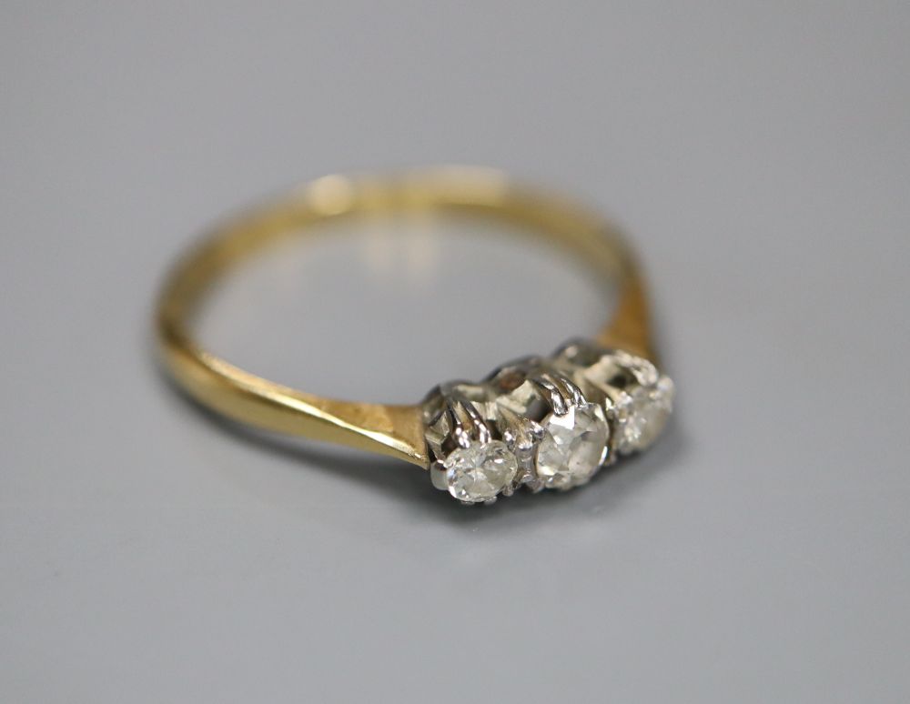 An 18ct & Pt, three stone diamond ring, size M/N, gross 1.8 grams.
